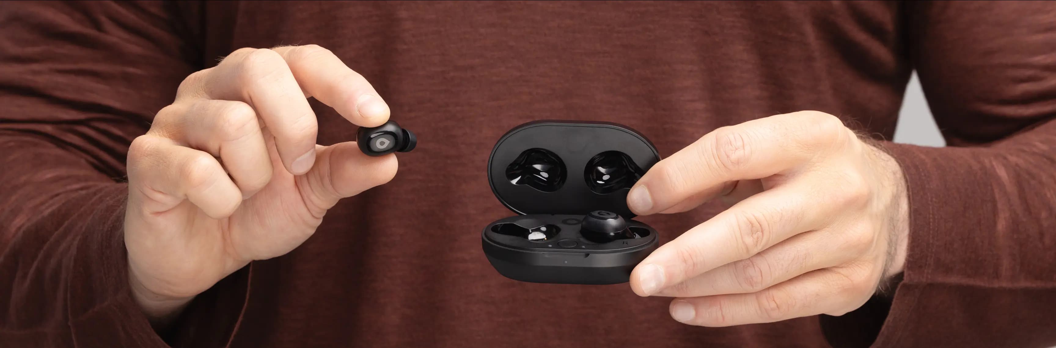 Hands holding Rosebud hearing aids